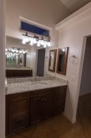 Vanity in master bathroom with window over the mirror