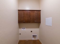Upper cabinets mounted above location for washer and dryer in laundry room