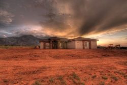 evening lighting rays from behind new custom home in Hereford, AZ