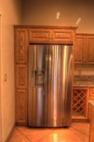Stainless steel fridge wrapped with custom built cabinetry
